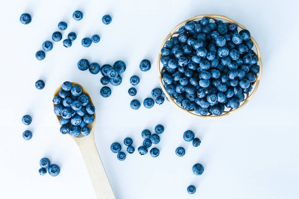 Freshly picked blueberries in wooden bowl. fresh blueberries on a white rustic table. selective focus. - Photo, Image