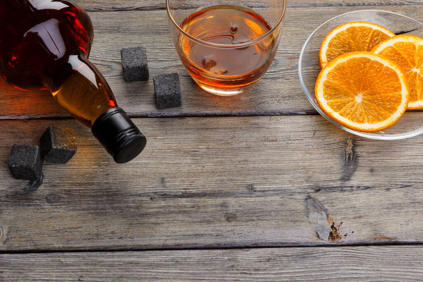 Whisky glass with orange fruit cut on dark wooden background - Φωτογραφία, εικόνα