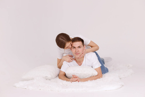 girl and guy on blanket with pillows together happy on an isolated background - Фото, изображение