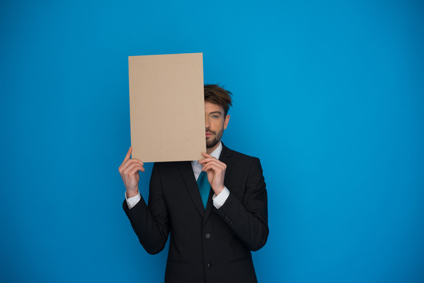 Businessman holding blank poster - Fotoğraf, Görsel