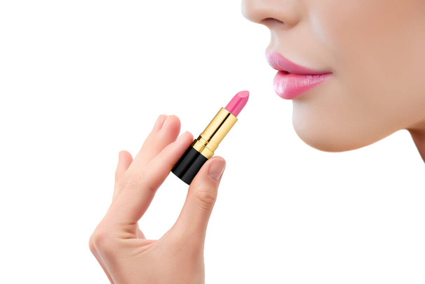 白い背景に隔離されたピンクの口紅を適用する美しい若い女性の閉鎖 - 写真・画像
