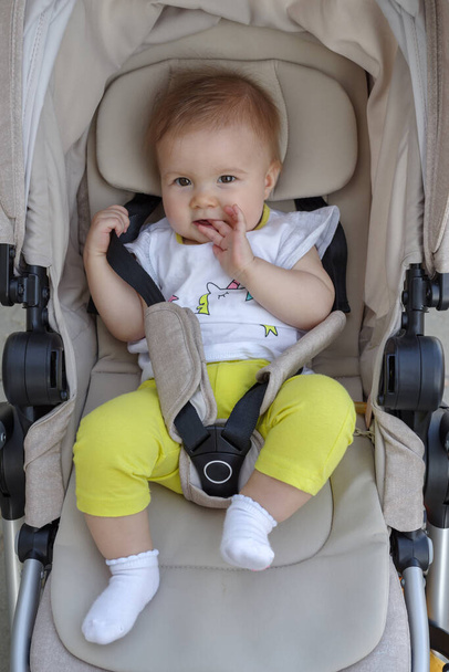Close-up of cute baby girl in baby stroller outdoor - Photo, Image