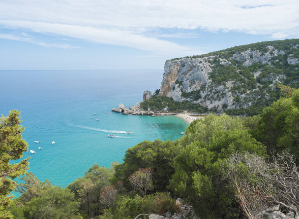 Letecký výhled na pláž Cala Luna poblíž Cala Gonone, Orosejský záliv, ostrov Sardinie, Itálie. Bílá písečná pláž s vápencovými kameny a tyrkysově modrou vodou. Slavná turistická destinace - Fotografie, Obrázek