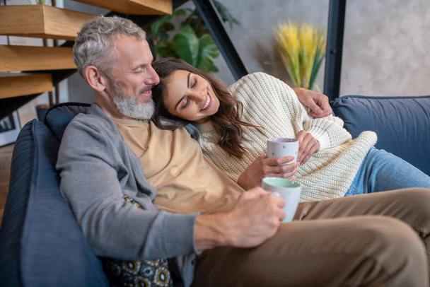 Married couple resting at home and having coffee - Foto, afbeelding
