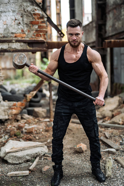Be strong. Man with sexy muscular torso looks brutally. Male with iron hammer. Masculinity and brutality concept. - Photo, image