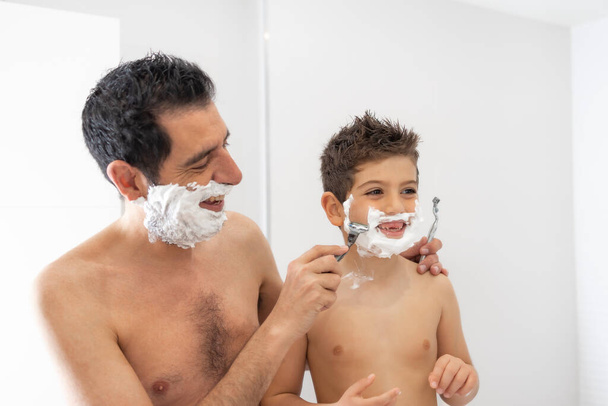 Funny father and son shaving in the bathroom - Photo, Image