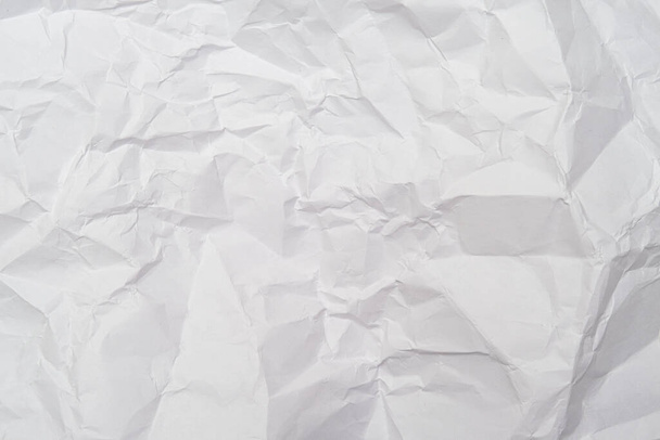 A background of sheet of white crumpled paper with wrinkles, backdrop for design and web - Foto, Bild