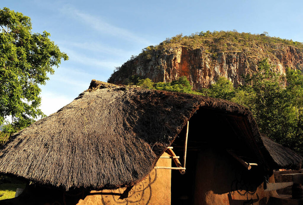 Традиционная африканская хижина у подножия скального и зеленого обнажения в сельской местности Мпумаланга в Южной Африке - Фото, изображение