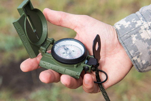 Man with compass in hand outdoor - Photo, Image