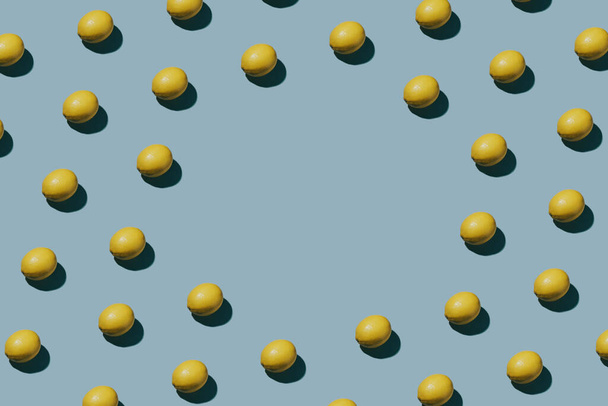 Creativo motivo limone fresco su sfondo blu. Concetto flat lay con copyspace - Foto, immagini