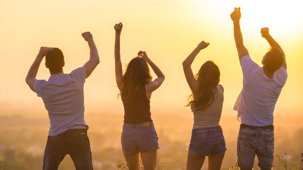 The four people dancing on the sunrise background - Photo, Image