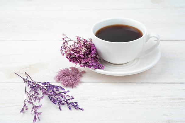 Lila Blumen und Kaffee auf weißem Hintergrund. Seitenansicht, mit Platz zum Kopieren. - Foto, Bild