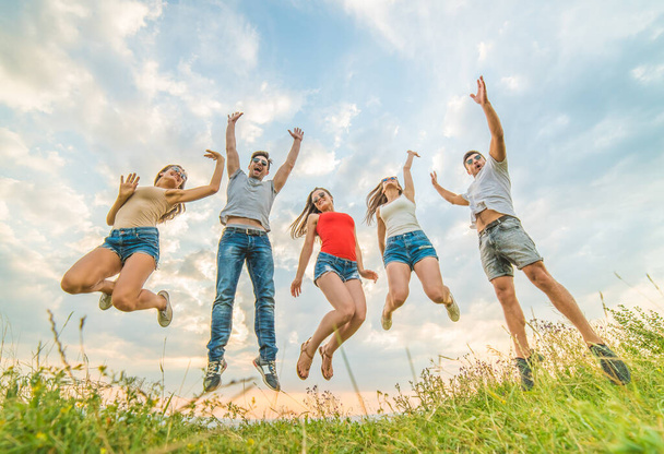 Onnelliset ystävät hyppivät pilvien taustalla - Valokuva, kuva