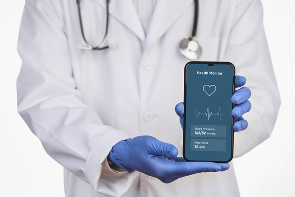 Physician holding a phone with health check app - Foto, afbeelding