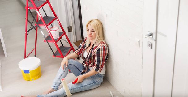 happy woman makes repairs in room at home - Valokuva, kuva