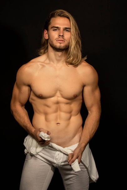 Sexy deporte músculo strong face rubio chico con pelo largo en ropa interior blanca en negro aislado fuente de fondo - Foto, Imagen