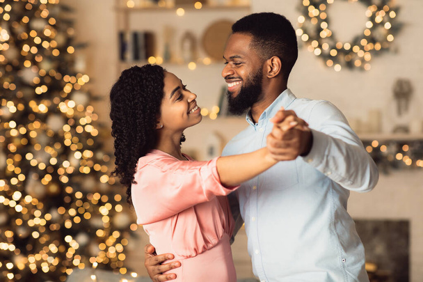 glimlachende zwarte man dansen met zijn mooie vrouw - Foto, afbeelding