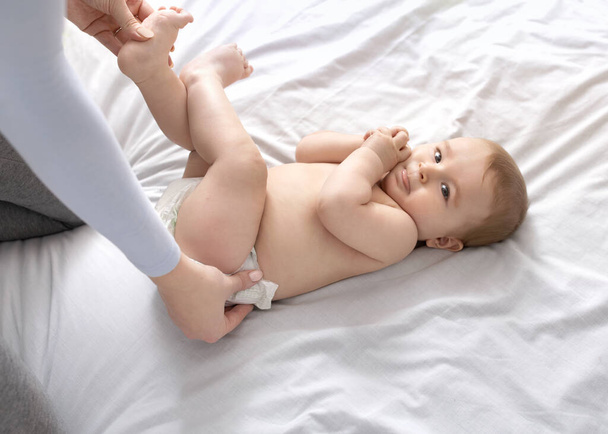 Moeder veranderende babys luier op wit, bovenaanzicht - Foto, afbeelding