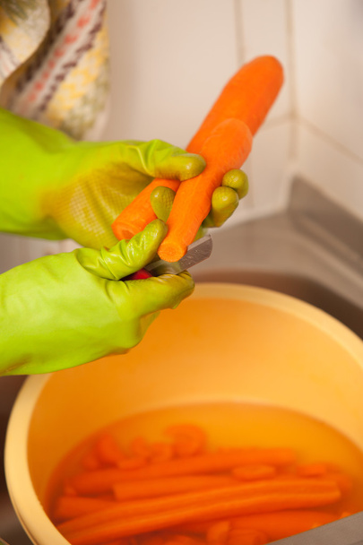 Woman hands slicing carrots in kitchen. Healthy nutrition - Photo, image