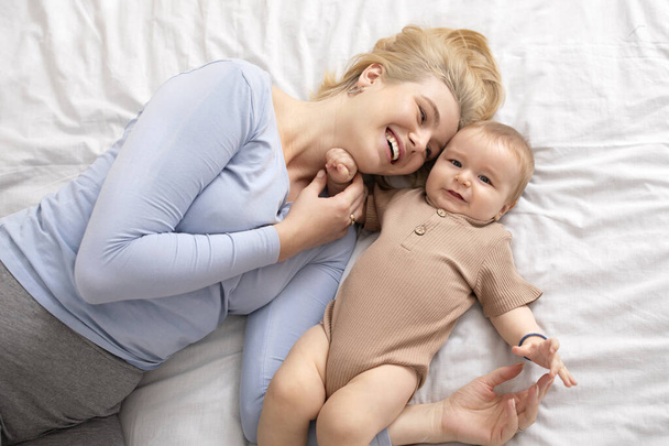 Bovenaanzicht van moeder en baby op bed - Foto, afbeelding
