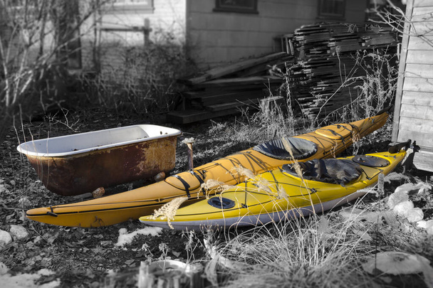 Two brightly colored kayaks and one old rusty tub stand outside - Photo, Image