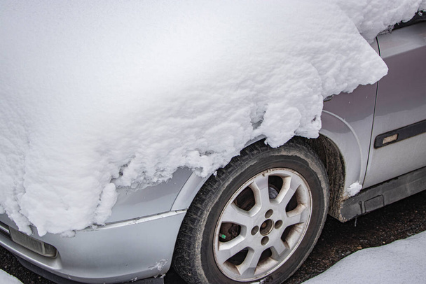 雪に覆われた冷凍車の雪で覆われた。冬の道。冬の運転の危険性。車の雪の除去。危険な交通状況. - 写真・画像
