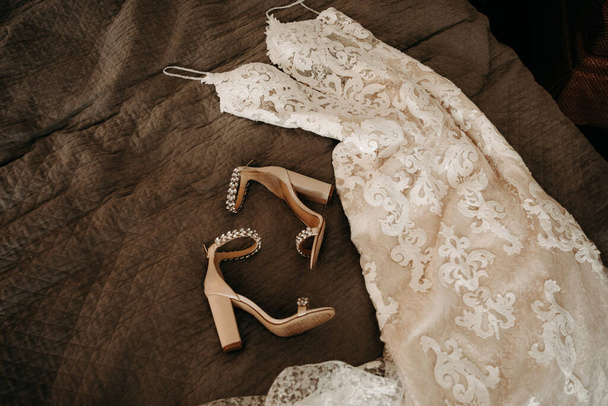 Bridal details - wedding dress, shoes and ring on the bed. |Bridal morning, getting ready lifestyle - Foto, Imagen