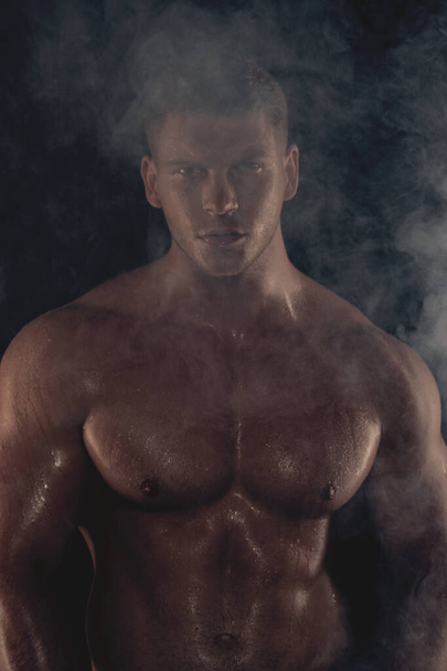 Sexy sport muscle fit strongface guy with white towel on black isolated  font background with smoke - Фото, изображение