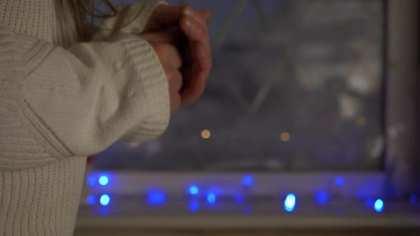 Nő melegítő kezét karácsonyi jelenet ablak - Felvétel, videó