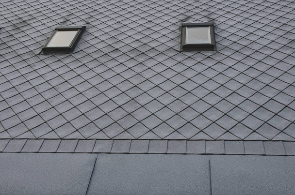tuiles de toit gris avec des fenêtres modèle carré en ardoise. posé obliquement. quadrillage carré. le bord inférieur du toit est formé d'une bande métallique pour encadrer et mieux arracher une couche de neige. - Photo, image