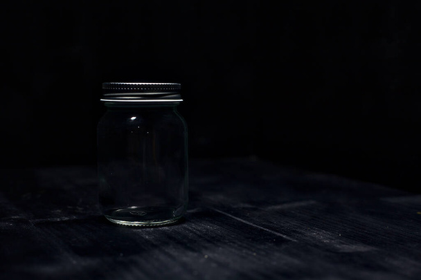 Un frasco sobre una superficie negra - Foto, imagen