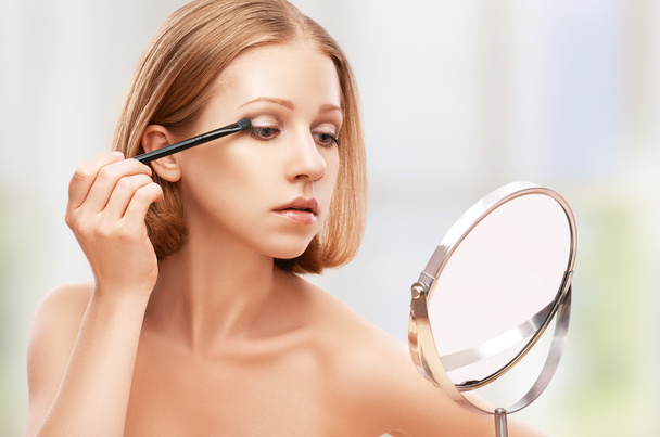 krásná žena, která dělá make-up štětcem v zrcadle - Fotografie, Obrázek