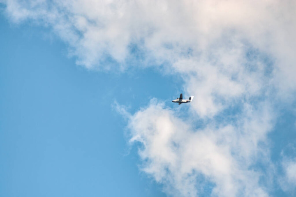 the plane flies in the cloudy sky - Фото, изображение