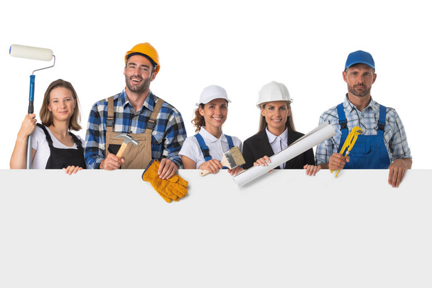 Group of industrial workers with blank banner. Isolated over white background. - Zdjęcie, obraz