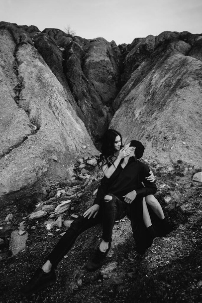 Asian couple in love hugs sitting on the rocks. Love story - Фото, изображение