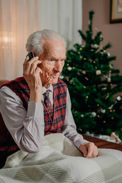高齢者シニア男はクリスマス休暇でモバイルで話して - 写真・画像