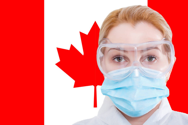 Маленька дівчинка з маскою дивиться на камеру на тлі прапора Канади. Концепція уваги до всесвітнього поширення коронавірусу по всьому світу. Коронавірус у Канаді.. - Фото, зображення
