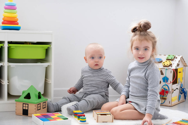 bebé niño jugando con hermana mayor con juguetes de madera. desarrollo infantil temprano - Foto, Imagen