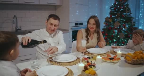 Šťastná velká bělošská rodina různých generací, oslavující Vánoce doma. Lidé jedí, mluví a usmívají se. - Záběry, video