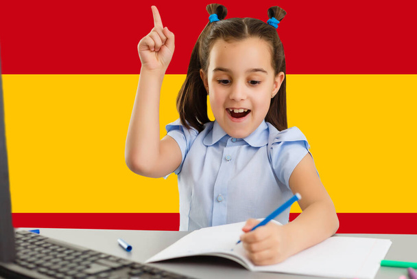 Изучение европейского языка. Умная девочка на фоне флага Испании - Фото, изображение