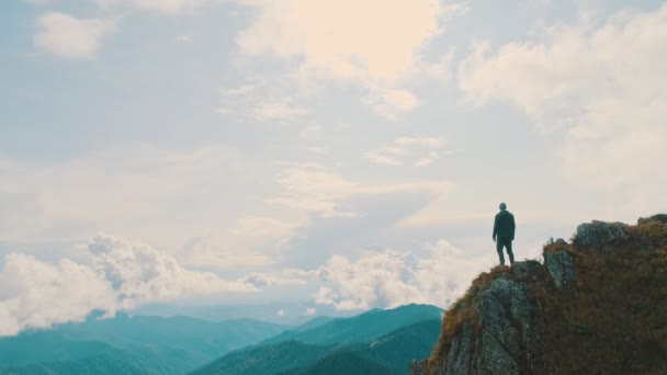 De man die op een bergklif staat met een prachtig landschap - Video
