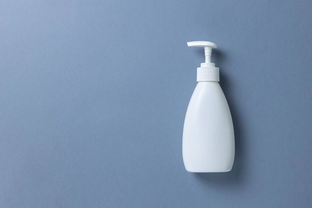 White bottle with hand soap, shower gel or body cream on gray background, mock up with place for text or copy space. Personal hygiene, skin care concept. Horizontal. Minimal style. Flat lay, top view. - 写真・画像