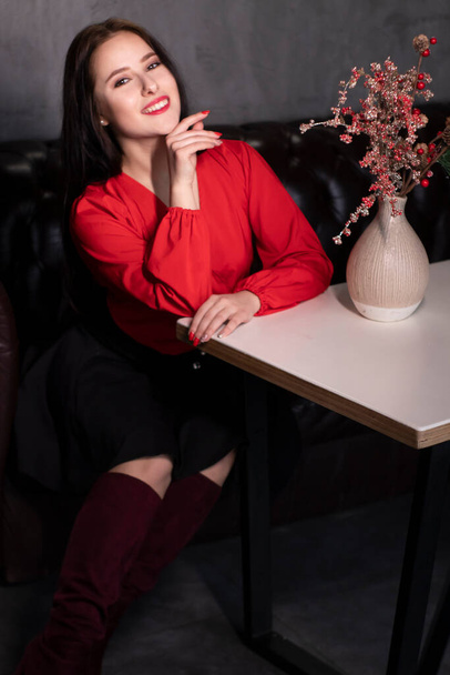seksikäs houkutteleva brunette nainen punainen pusero ja musta hame parvi vintage kahvila lähellä maljakko koriste kuohuviini punainen oksat. Kopioi ystävänpäivä  - Valokuva, kuva