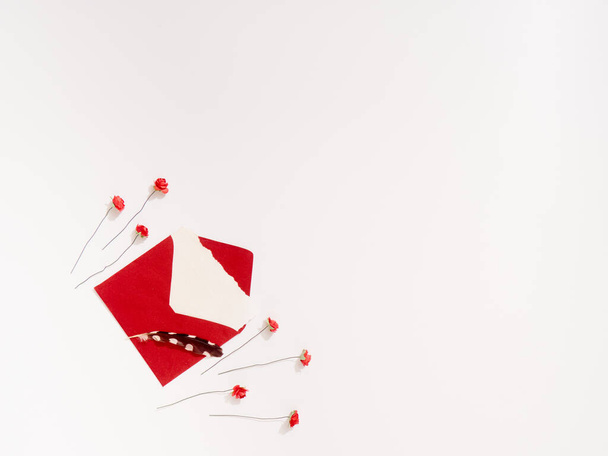 Изолированные бумажные красные розы и конверт с пером на белом фоне с копировальным пространством - Фото, изображение