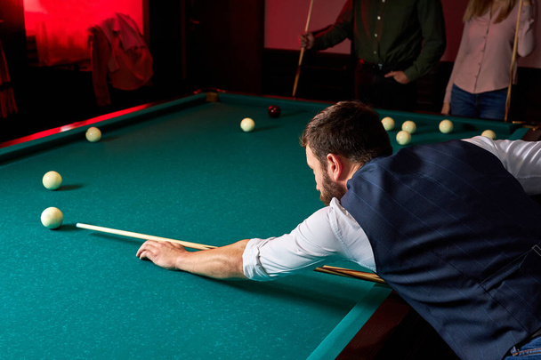 young man playing snooker, lining to hit ball on pool billiards table - Foto, Imagem