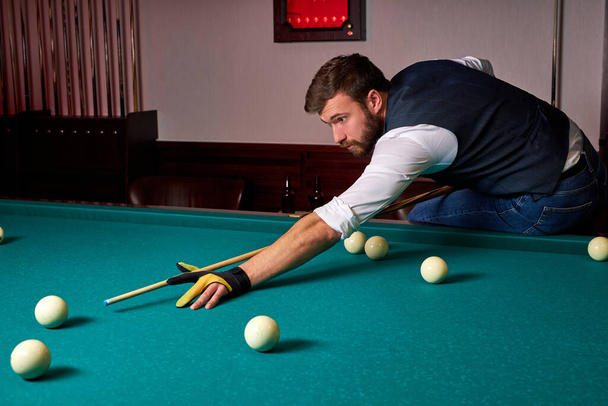 young man is playing snooker, he is aiming to shoot the snooker ball - Fotoğraf, Görsel