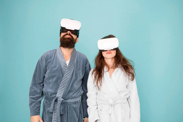 Awakening from virtual reality. Couple in bathrobes wear vr glasses. Conscious awakening. Return to reality. Man and woman explore vr. VR technology and future. VR communication. Exciting impressions - Fotoğraf, Görsel