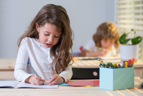 Children, cute girl drawing in classroom at school. - Photo, image