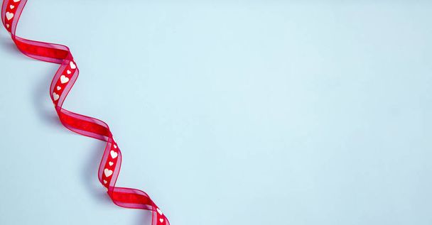 Piros szatén szalag szívvel a kék háttér - Valentin-napi banner  - Fotó, kép
