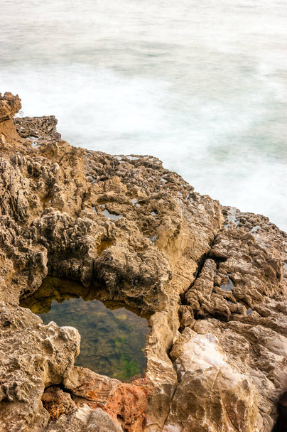 Dziura z wodą w formacjach skalnych obok Oceanu Atlantyckiego w pobliżu Hell 's Mouth (w języku portugalskim Boca do Inferno) w Cascais, Portugalia - Zdjęcie, obraz
